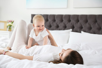 Canvas Print - Happy mother with little baby on bed at home. Crawling time