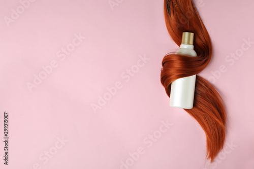 Shampoo Bottle Wrapped In Lock Of Hair On Pink Background Flat