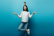 © LIGHTFIELD STUDIOS - smiling brunette asian woman meditating with coffee to go on head on blue background