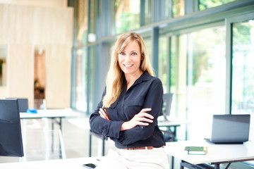 Confident mature businesswoman standing in the office