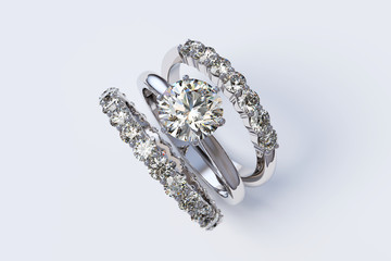 Solitaire diamond engagement ring, two eternity rings  on white background.