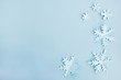 © Elena - Winter and christmas concept. Snowflakes made of paper on a light blue background. Background for design, minimal composition. Top view, flat lay, copy space