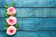 Wedding Border With Three Pink Rose Flowers On Blue Wooden Background