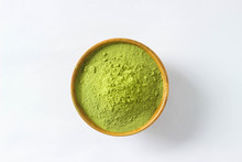 Closed Up And Top View Extract Mathcha Green Tea Powder In Mini Brown Wooden Bowl On White Paper Background.