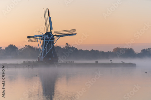 Cuadros en Lienzo Nature awakens at a traditional Dutch windmill during a foggy sunrise