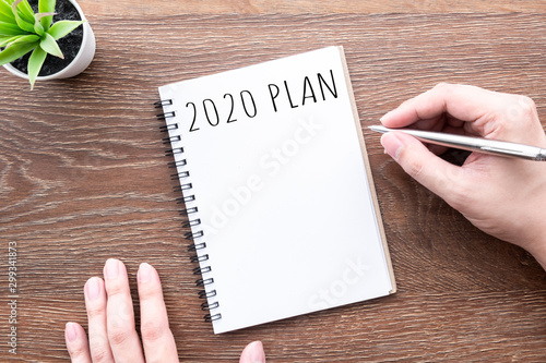 Cuadros en Lienzo Man hand is going to write 2020 plan and goals on notebook