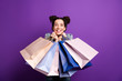 © deagreez - Portrait of positive cheerful girl have fun on shopping hold many bags packages feel content expression wear denim jeans jacket isolated over purple color background