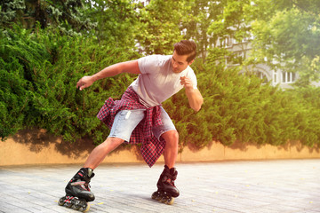 Poster - Handsome young man roller skating outdoors on sunny day