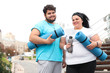 © New Africa - Overweight couple in sportswear with mats outdoors
