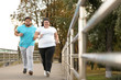 © New Africa - Overweight couple running together in park