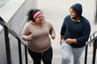 © New Africa - Overweight couple running up stairs together outdoors