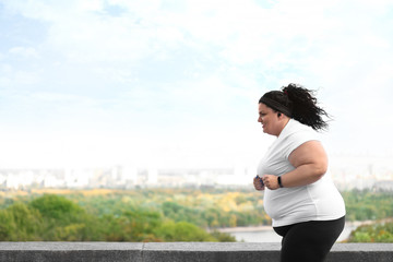 Wall Mural - Beautiful overweight woman running outdoors. Fitness lifestyle