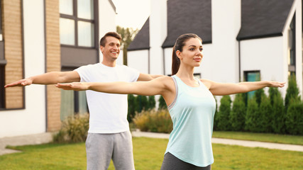 Canvas Print - Sporty couple doing exercise on backyard. Healthy lifestyle