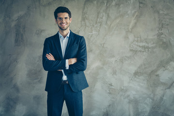 Photo of cheerful handsome attractive brunet haired entrepreneur with arms crossed smiling toothily showing his success by wearing expensive formal suit isolated grey color background