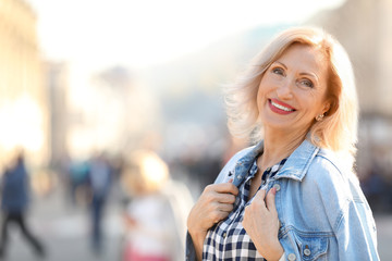 Portrait of happy mature woman on city street