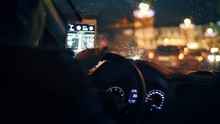 Taxi Driver Driving At Night In Illuminated City Streets. Shallow DOF, 4K UHD.