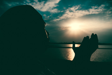 Silhouette Young asian muslim man praying on sunset,Ramadan festival concept