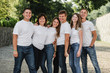 © Vadym - Happy family in white T-shirt and jeans emracing and having fun. Parents with their adult children walking in the park. Family time concept
