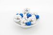 Blaue und silberne Weihnachtskugeln auf einem weißen Teller