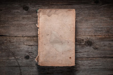 Closed Book On Vintage Wooden Background.  Old Book On The Wooden Table. Closed Book With Empty Cover Laying On Wooden Table.