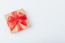 Cardboard Gift Box With Red Bow On White Background. Flat Lay. Top View. Copy Space For Your Text.