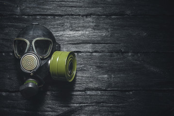 Gas mask on a black wooden background. Post apocalypse.