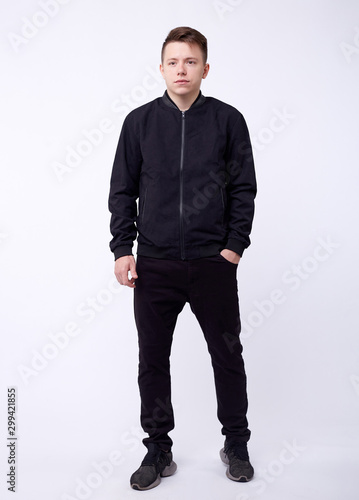 Fotografía Young man in jeans, black bomber jacket on white background.
