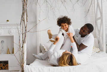 Family laying down together in a bed