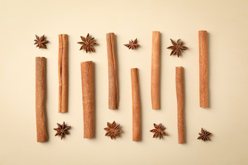 Poster - Flat lay with cinnamon sticks and anise stars on beige background, space for text