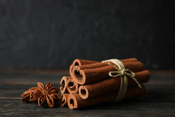 Poster - Cinnamon sticks and anise stars on wooden background, space for text