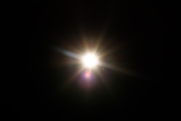 Lens Flare. Light over black background. Easy to add overlay or screen filter over photos. Abstract sun burst with digital lens flare background. Gleams rounded and hexagonal shapes, rainbow halo.