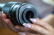© Milan - Old vintage manual photo lens in women's hands with manicured nails