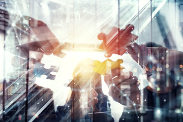 Business people join puzzle pieces in office. Concept of teamwork and partnership. double exposure with light effects