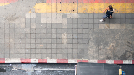 Aerial view and top view with blur man walk in business area with pedestrian street and red and yellow block walkway