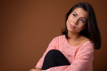 Wall Mural - Portrait of beautiful multi ethnic woman sitting on the floor