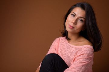 Wall Mural - Portrait of beautiful multi ethnic woman sitting on the floor