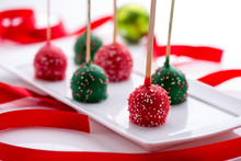 Christmas Cake Pops On A White Plate With Red Ribbon