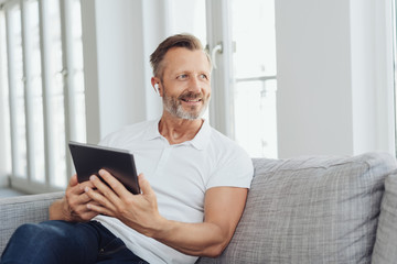Middle-aged man listening to music on an ear bud