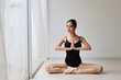 © feeling lucky - attractive young asian woman in ballet dress exercising and sitting in yoga pose while resting at home