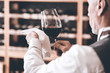 Sommelier Concept. Senior man standing wiping glass of wine diligently back view close-up