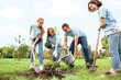 © Viktoriia - Volunteering. Young people volunteers outdoors planting trees together pouring water on ground smiling cheerful