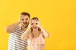 © Pixel-Shot - Portrait of happy young couple having fun on color background