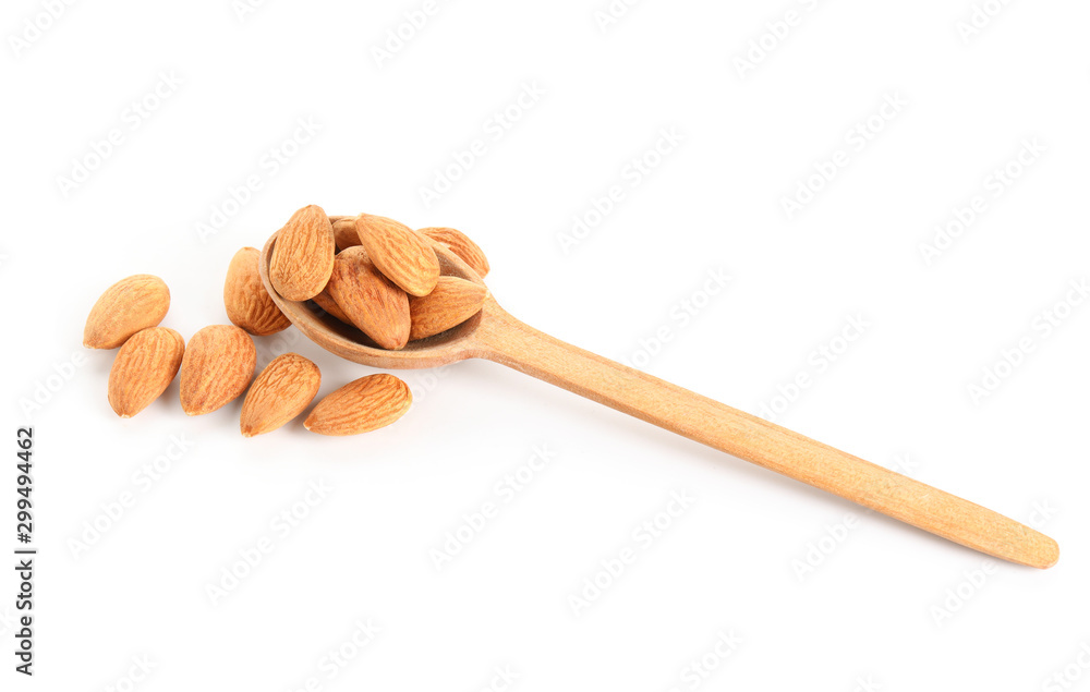Spoon with tasty almonds on white background