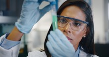 Portrait Of Dark Skin Female Scientist Is Analyzing A Liquid To Extract The DNA And Molecules In The Test Tubes In Laboratory. 