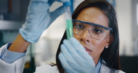 portrait of dark skin female scientist is analyzing a liquid to extract the dna and molecules in the