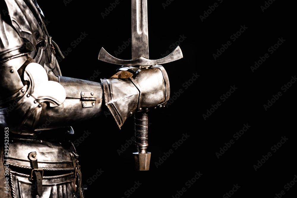 cropped view of knight in armor holding sword isolated on black - obrazy, fototapety, plakaty 