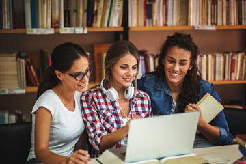 Wall Mural - Female students study in the college library.Learning and preparing for exam.Education concept.