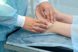 © familylifestyle - Surgeon palpates leg before surgery to remove ankle hygroma in joint, hands closeup. One day surgery concept. Examination before operation. Woman patient in hospital with doctor.