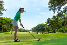 Healthy Sport. Asian Sporty Woman Golfer Player Doing Golf Swing Tee Off On The Green , People Presumably Does Exercise. Healthy Lifestyle Concept.