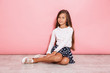Girl child posing isolated over pink wall background